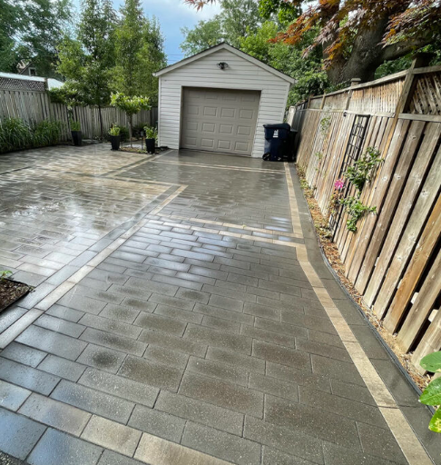 Beautifully restored interlock driveway by K Bros Landscaping — perfectly aligned stone pavers after professional repair